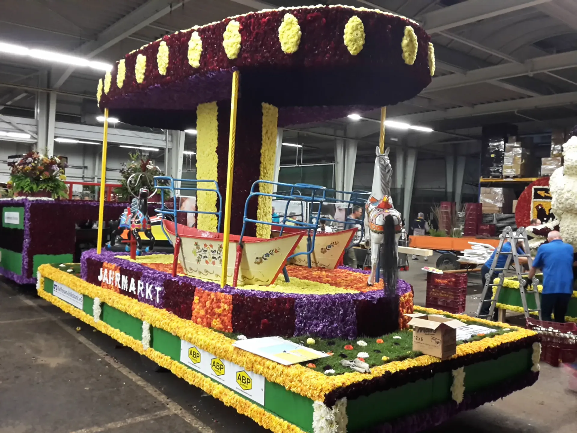 Der fertige, mit Blüten gesteckte Karussellwagen in der Halle
