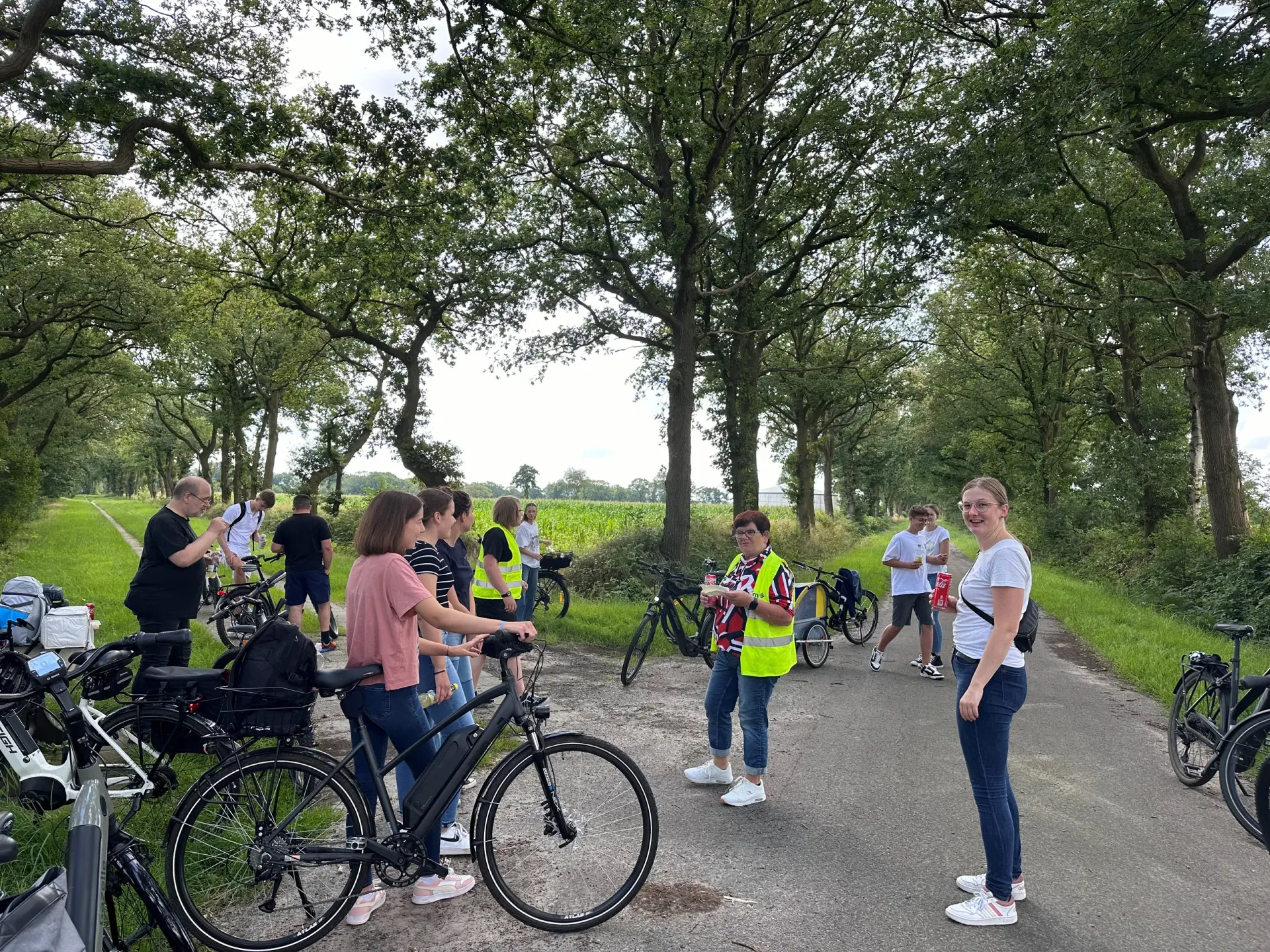 Die Radfahrerinnen und Radfahrer beim Halt an einer Allee