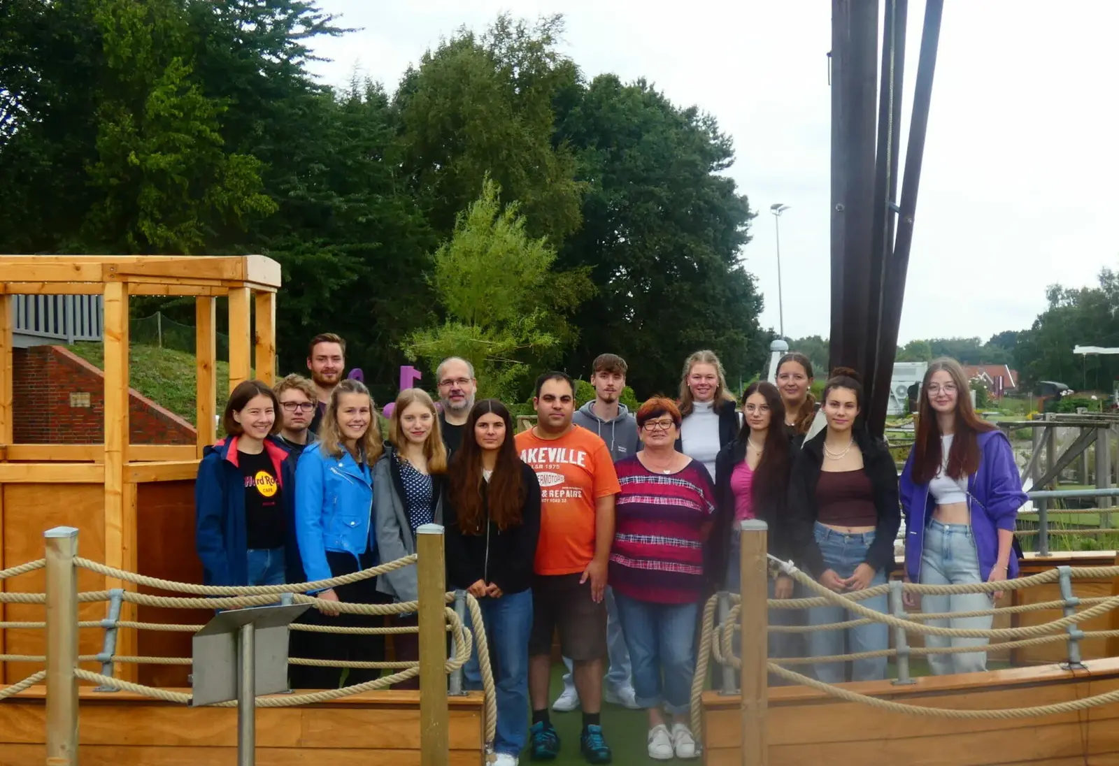 Das Team der Schwimmausbildung als Gruppe vor einem Holzspielplatz